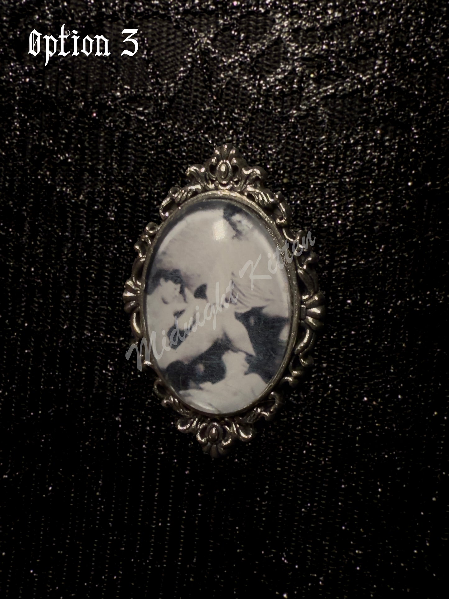 A silver ring with the decorative setting of a framed photograph on a hand against a textured black background. Option 3 contains a Victorian era pornographic image of a ménage à trois.
